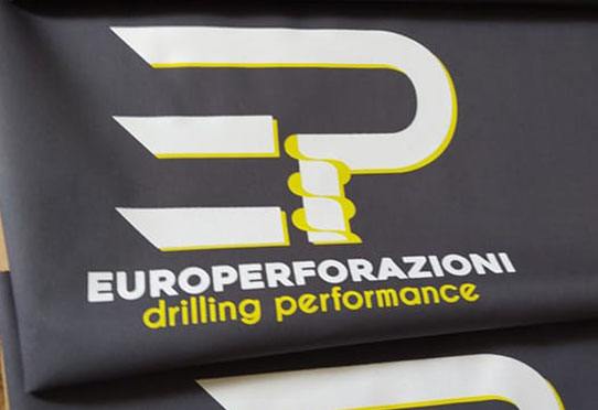 Teli tecnici neri stampati con logo aziendale nel settore perforazioni
